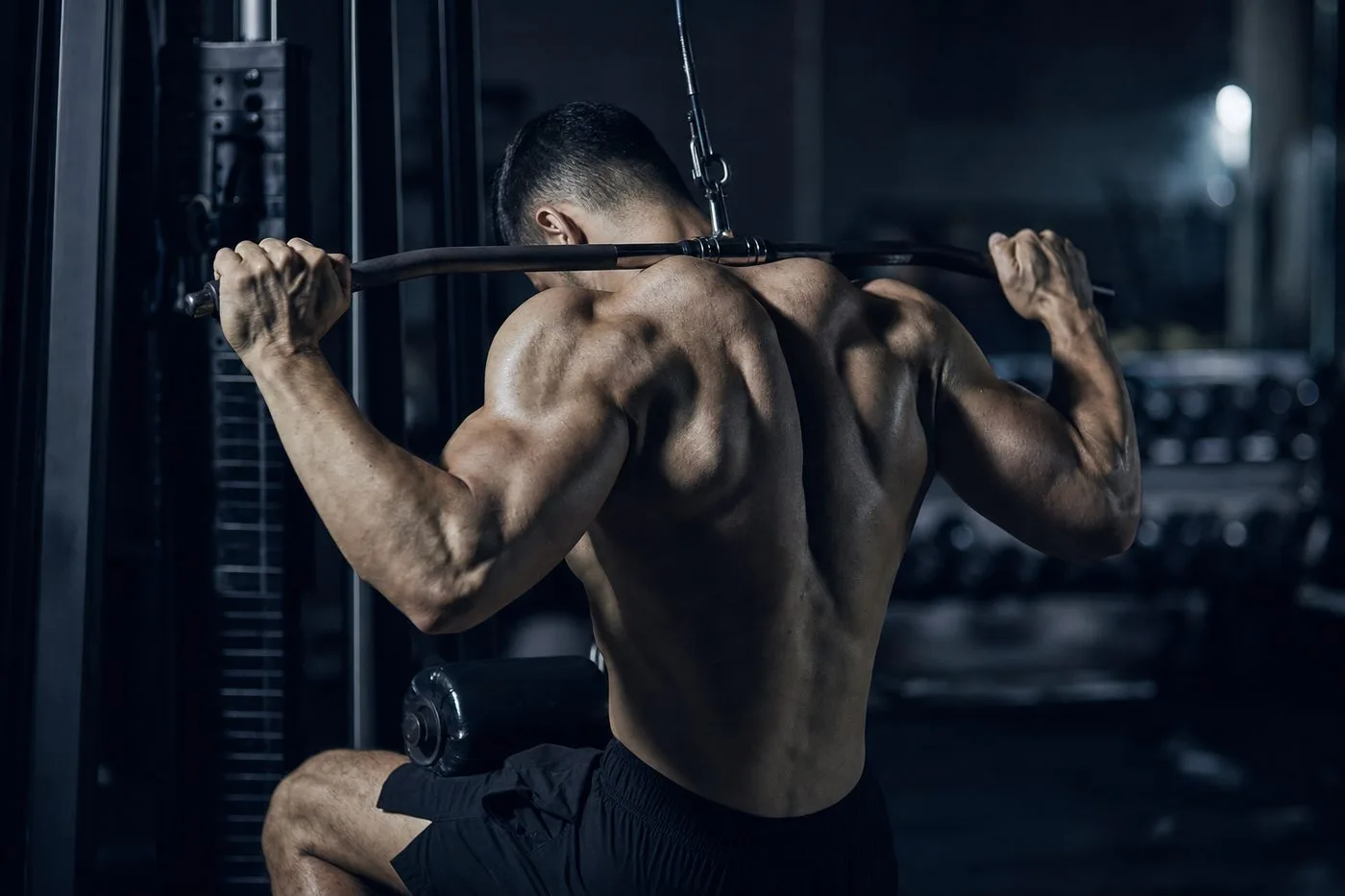 Athlete performing a behind-the-neck lat pulldown, showing the compromised shoulder and neck position