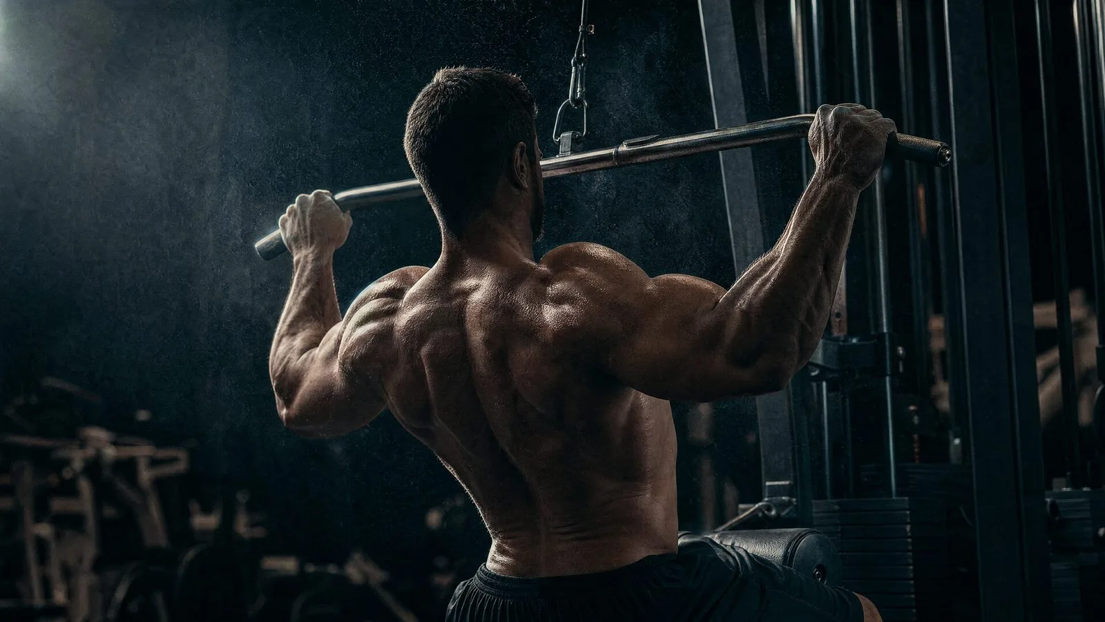 Athlete gripping a lat pulldown bar mid-pull, back muscles engaged